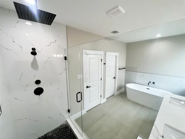 a spacious bathroom with a tub sink and shower