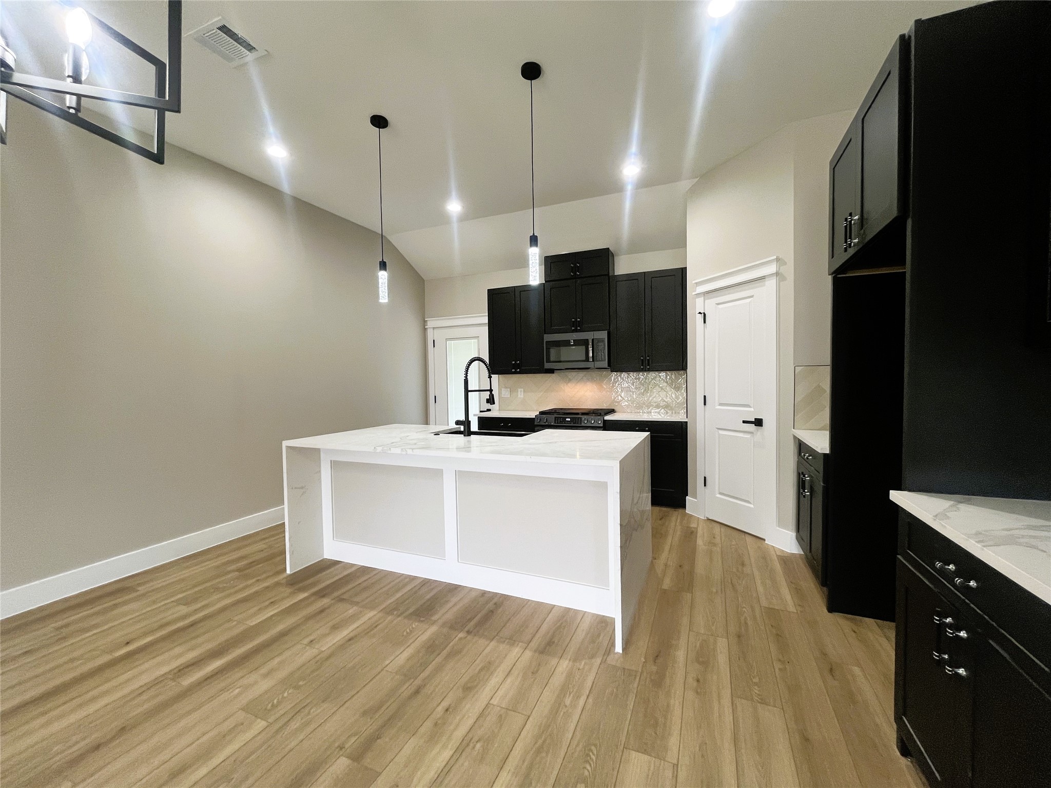 8914 Ivy Spring Lane Houston, TX 77088 - Photo 7 of 33 a view of a kitchen with kitchen island microwave and stove top oven