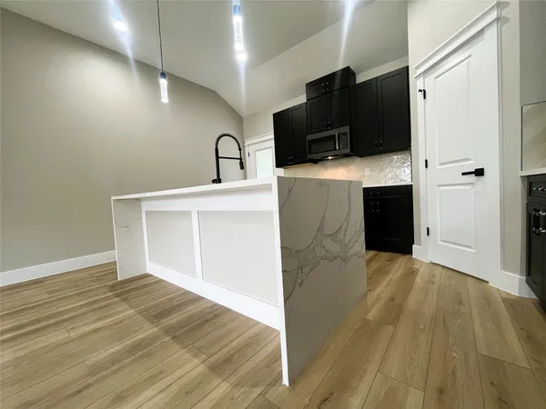 a view of a kitchen with wooden floor and a sink
