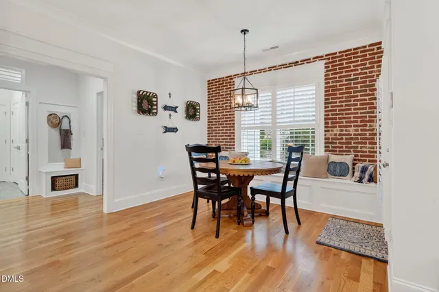 a kitchen with stainless steel appliances granite countertop a table chairs refrigerator and sink