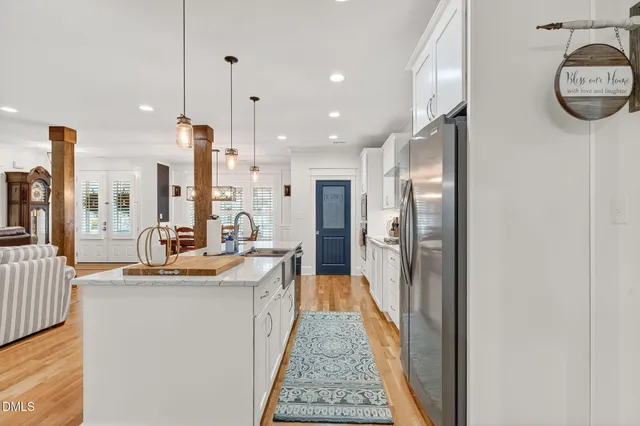 a kitchen with granite countertop a sink a center island stainless steel appliances and cabinets