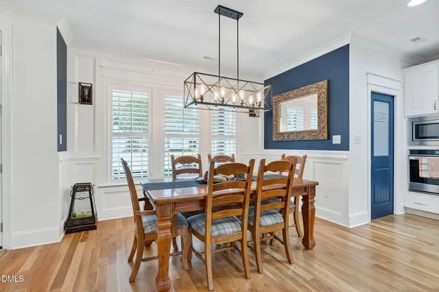 a view of a a dining room with furniture window and wooden floor