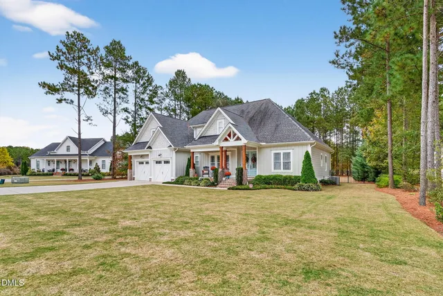 a front view of a house with a yard and trees