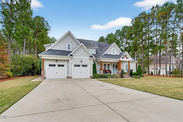 a front view of a house with a yard and trees