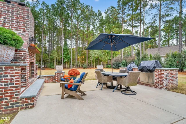 a view of backyard with table and chairs under an umbrella
