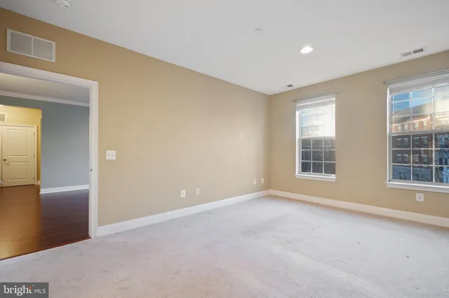 a view of an empty room with window and bathroom