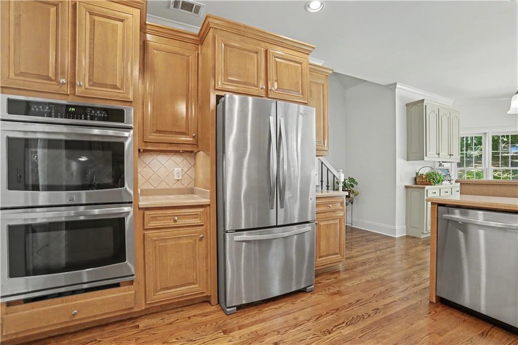 537 Old Collins Road Hoschton, GA 30548 - Photo 15 of 42 a kitchen with granite countertop wooden floors appliances and cabinets