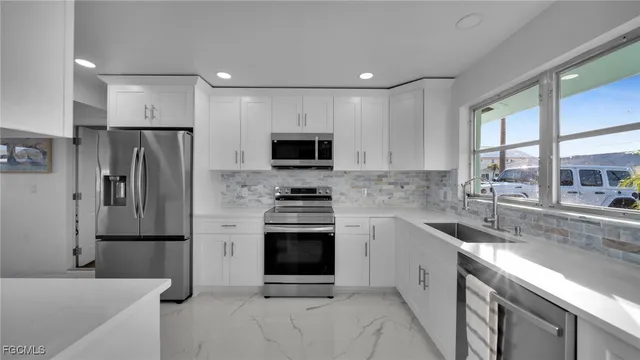 a kitchen with stainless steel appliances a refrigerator sink and microwave
