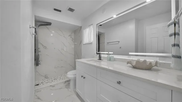 a bathroom with a double vanity sink toilet and shower