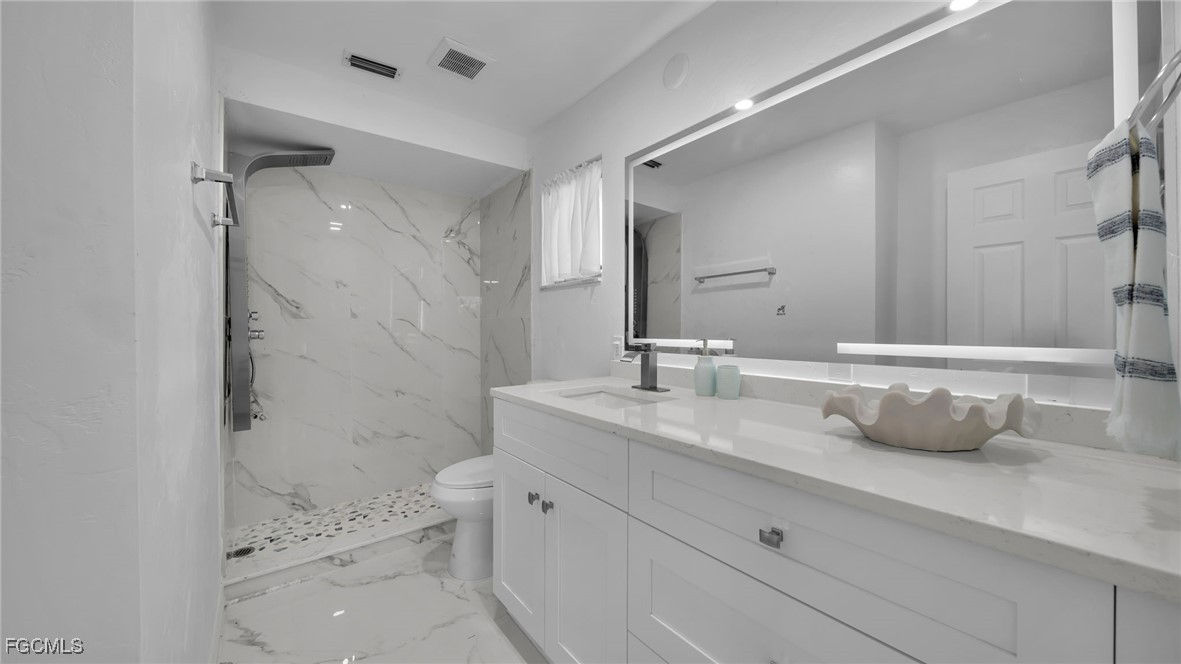 2758 Bruce Street Matlacha, FL 33993 - Photo 22 of 35 a bathroom with a double vanity sink toilet and shower