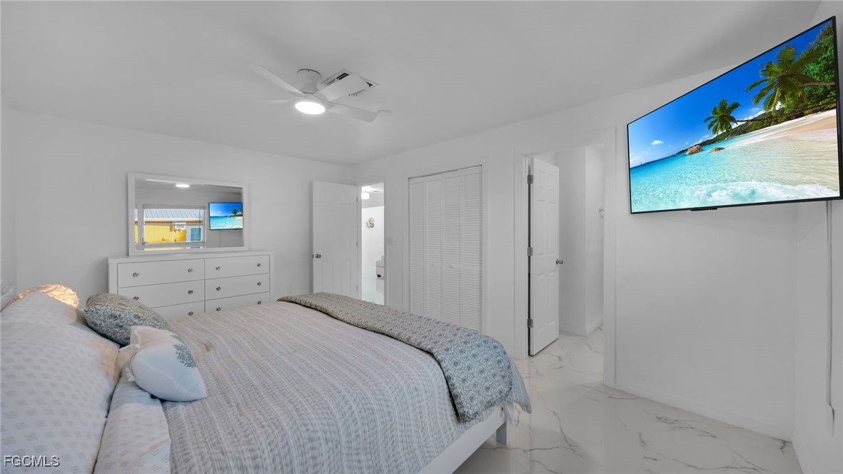 2758 Bruce Street Matlacha, FL 33993 - Photo 23 of 35 a spacious bedroom with a bed and painting on the wall