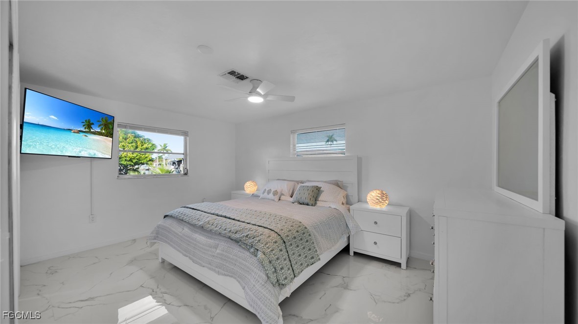 2758 Bruce Street Matlacha, FL 33993 - Photo 25 of 35 a bedroom with a bed and a painting on the wall