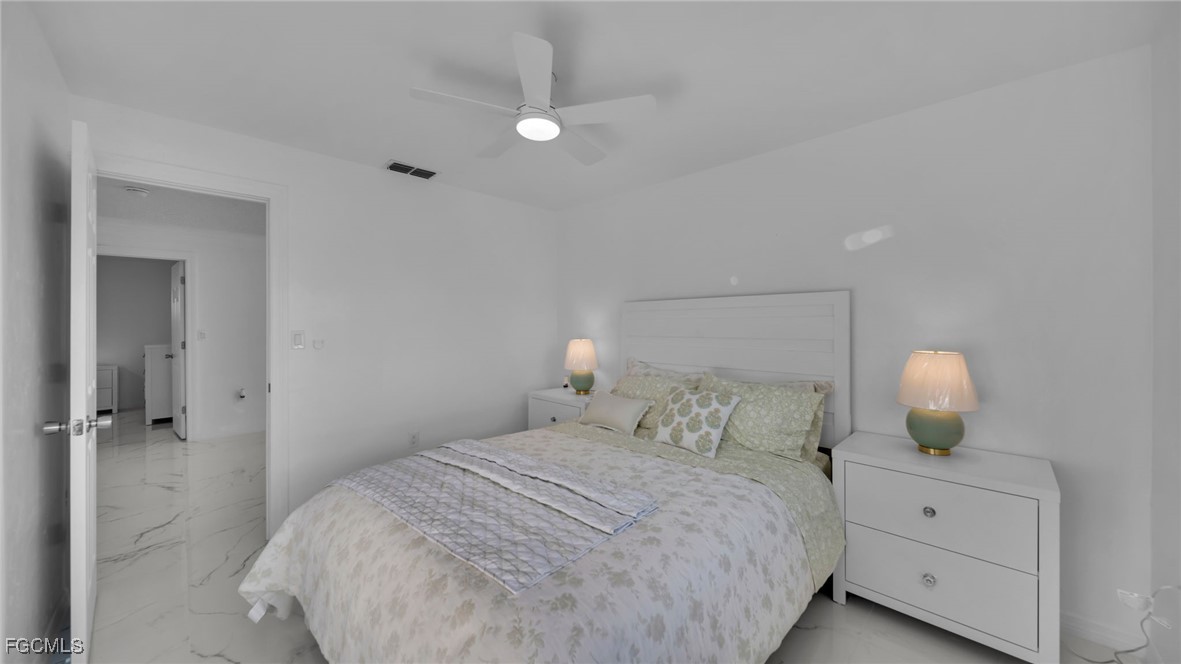 2758 Bruce Street Matlacha, FL 33993 - Photo 26 of 35 a bedroom with a bed and a lamp
