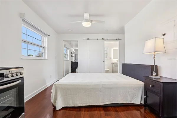 a bedroom with a bed and wooden floor