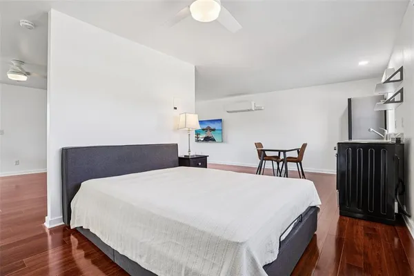 a large bedroom with wooden floor and a bed