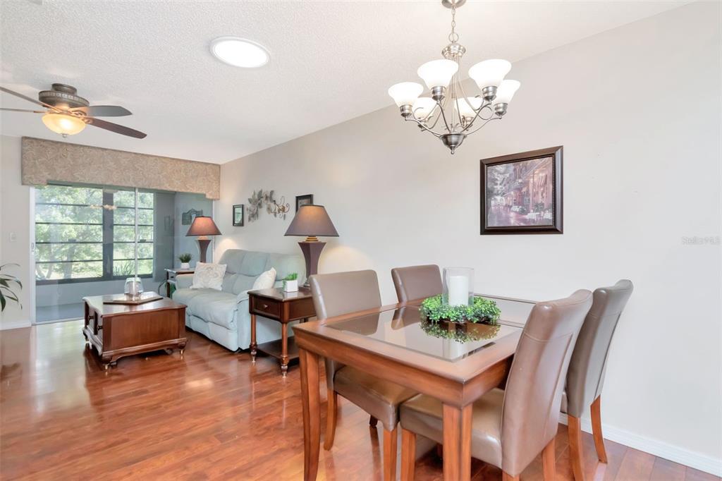 2281 Shelly Drive, Unit D Palm Harbor, FL 34684 - Photo 16 of 53 a view of a dining room with furniture wooden floor and a chandelier