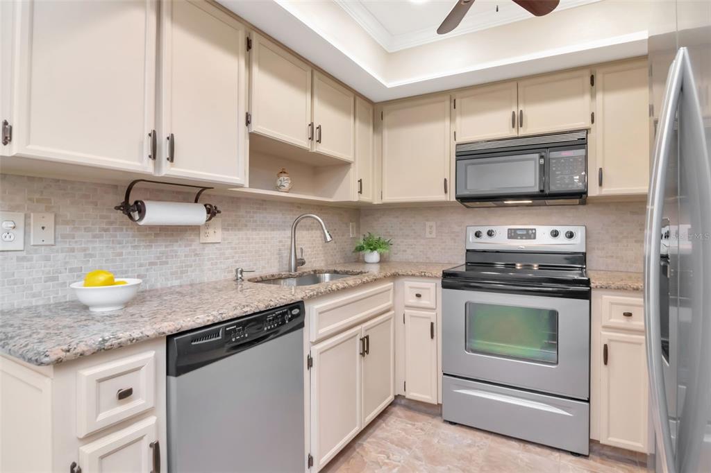 2281 Shelly Drive, Unit D Palm Harbor, FL 34684 - Photo 17 of 53 a kitchen with stainless steel appliances granite countertop a stove a sink and a microwave