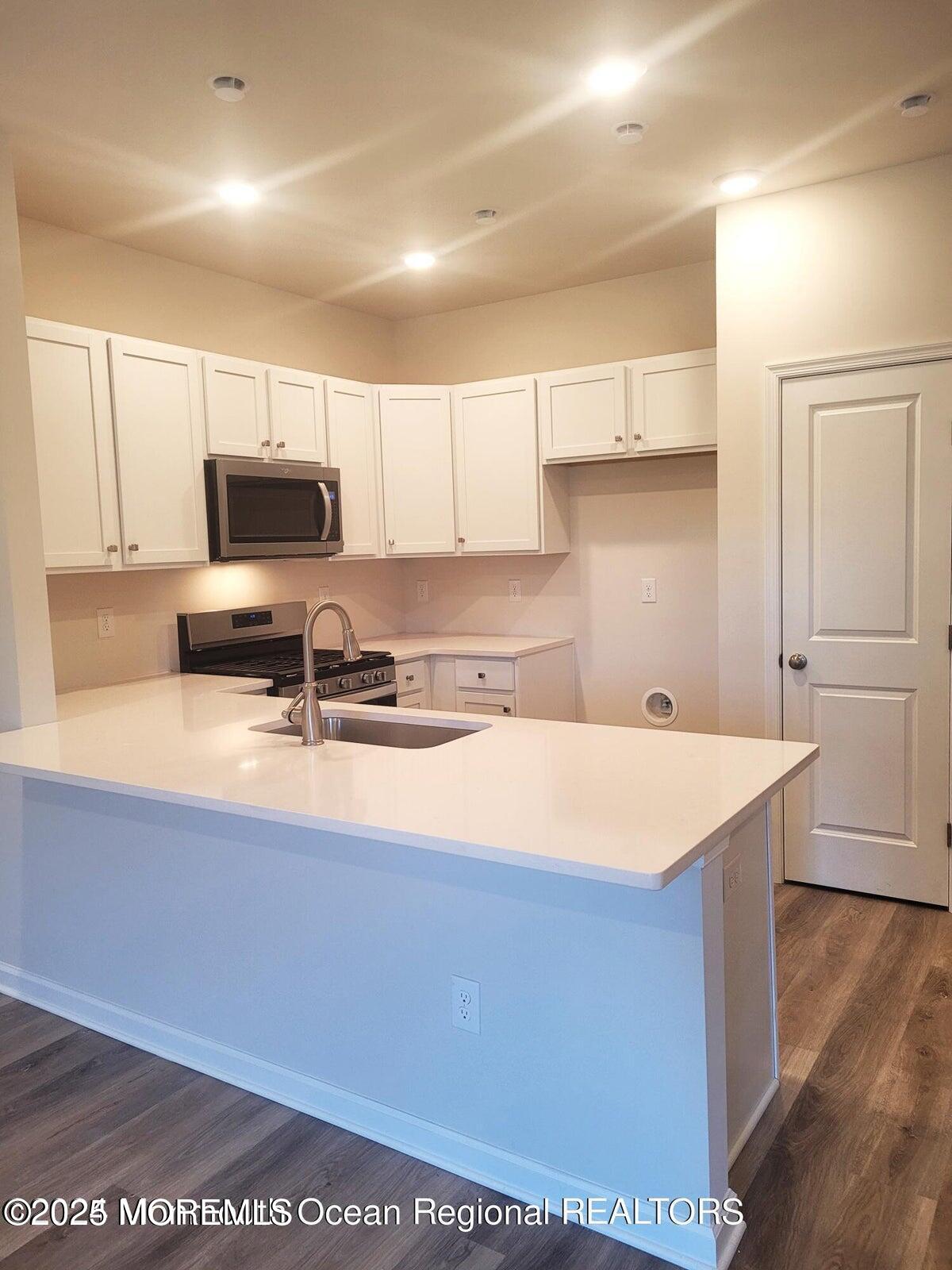 73 Nelsons Way Westampton, NJ 08060 - Photo 2 of 18 a kitchen with a sink a stove a microwave and cabinets