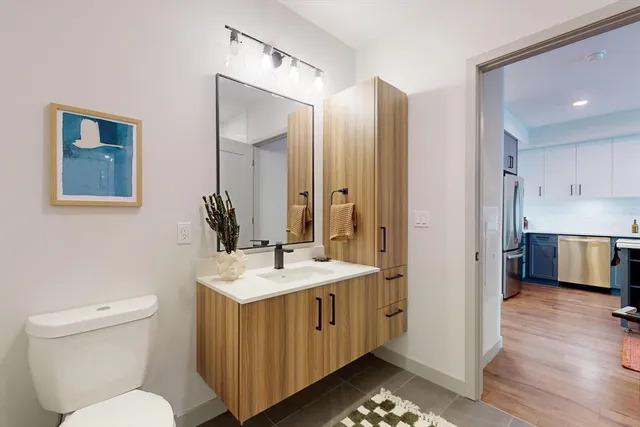 a spacious bathroom with a toilet sink and mirror