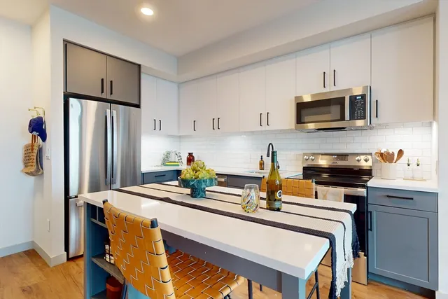 a kitchen with stainless steel appliances a stove refrigerator sink and microwave
