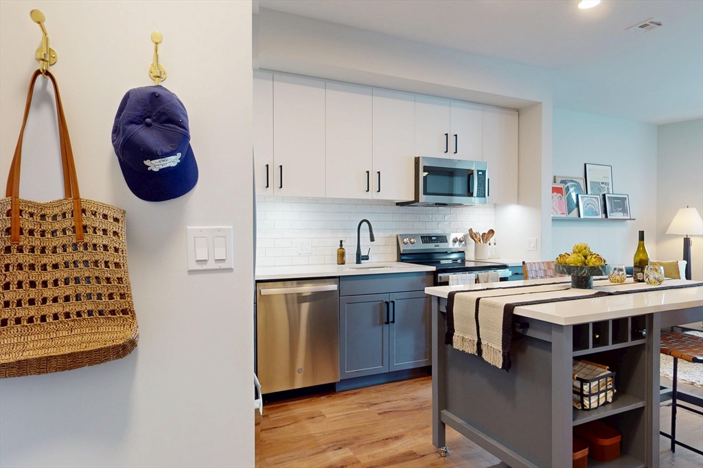 80 Rugg Road, Unit 1301 Boston, MA 02134 - Photo 20 of 20 a kitchen with stainless steel appliances granite countertop a stove a sink and a microwave