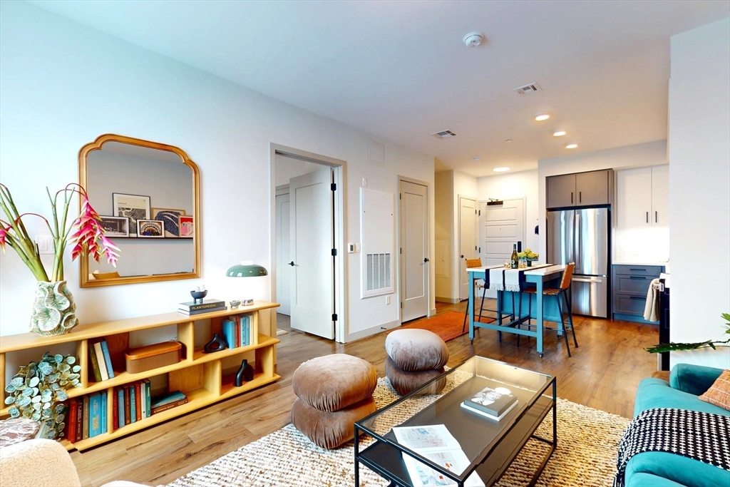 80 Rugg Road, Unit 1301 Boston, MA 02134 - Photo 2 of 20 a living room with furniture a rug and a book shelf