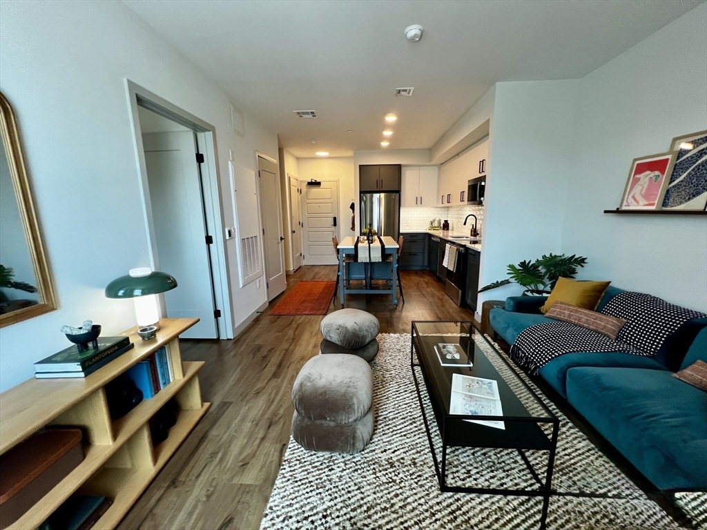 80 Rugg Road, Unit 1301 Boston, MA 02134 - Photo 3 of 20 a living room with furniture and a wooden floor