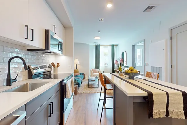 a kitchen with stainless steel appliances a sink stove and cabinets