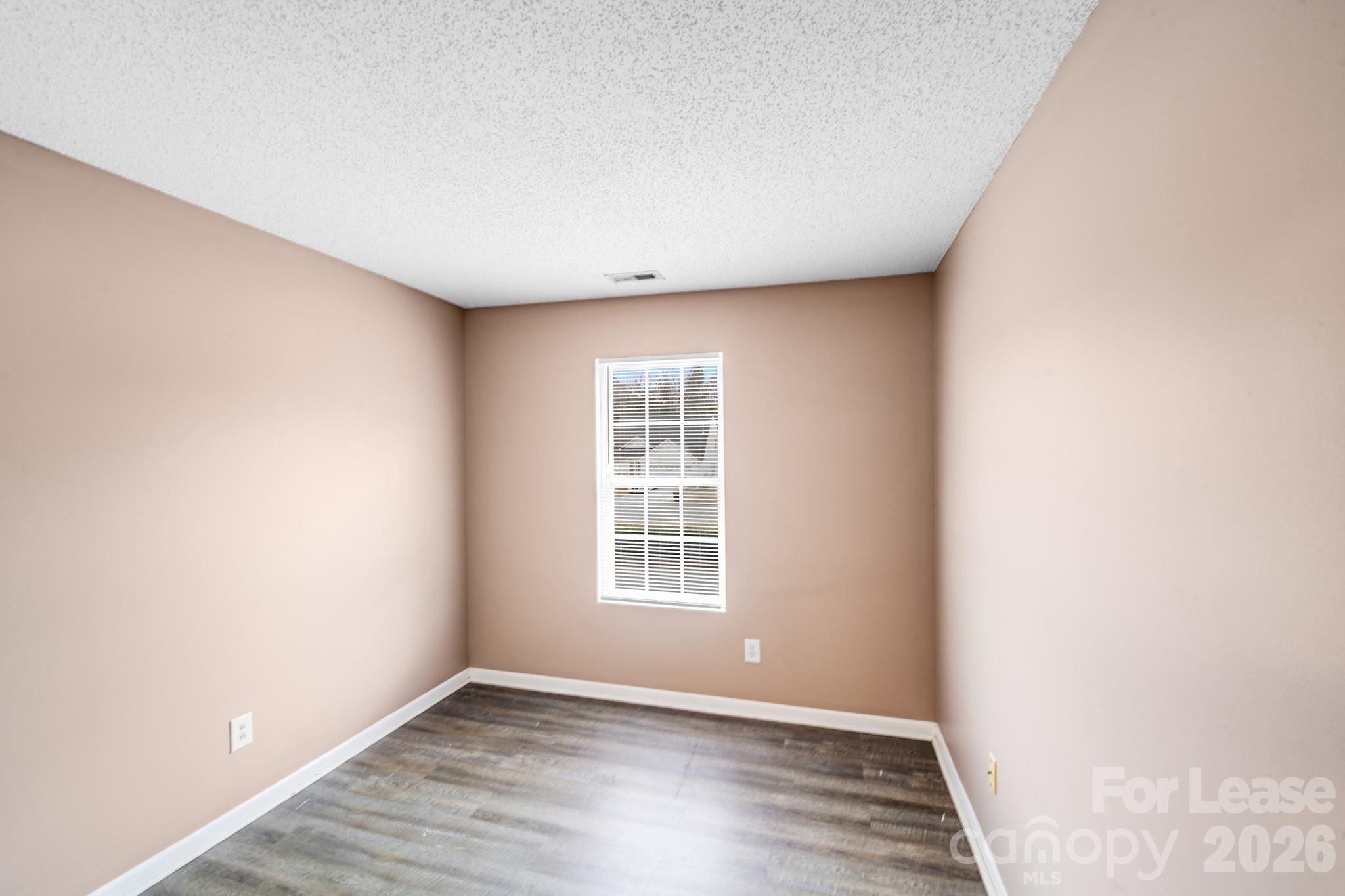 3260 Barons Court Road Charlotte, NC 28213 - Photo 16 of 25 a view of an empty room with wooden floor and a window