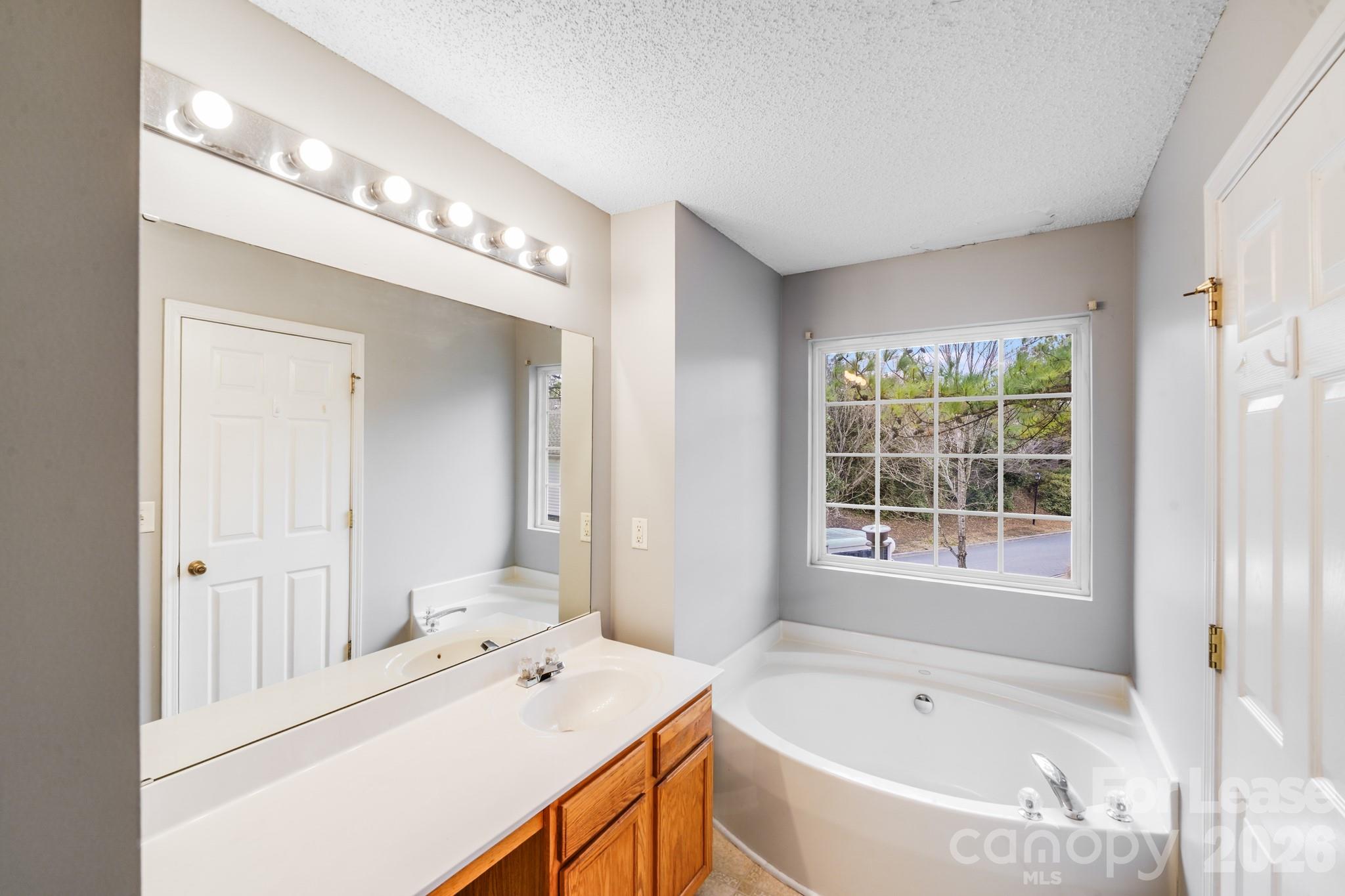 3260 Barons Court Road Charlotte, NC 28213 - Photo 21 of 25 a bathroom with a tub sink and mirror