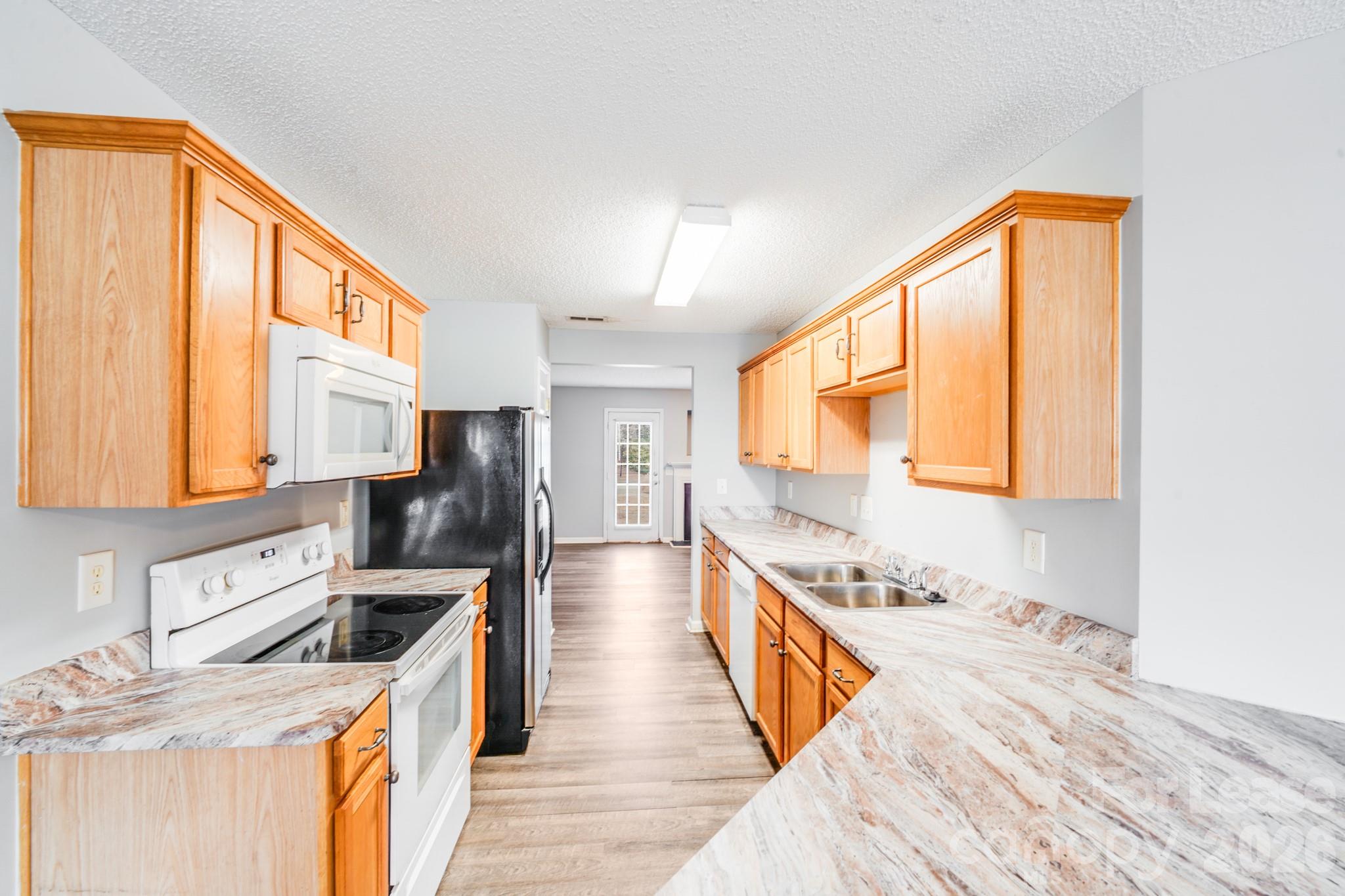 3260 Barons Court Road Charlotte, NC 28213 - Photo 3 of 25 a kitchen with a stove a sink and a refrigerator
