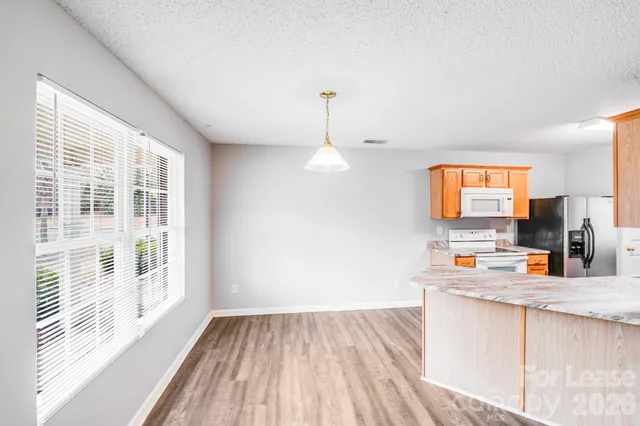 a kitchen with a sink wooden floor and a large window