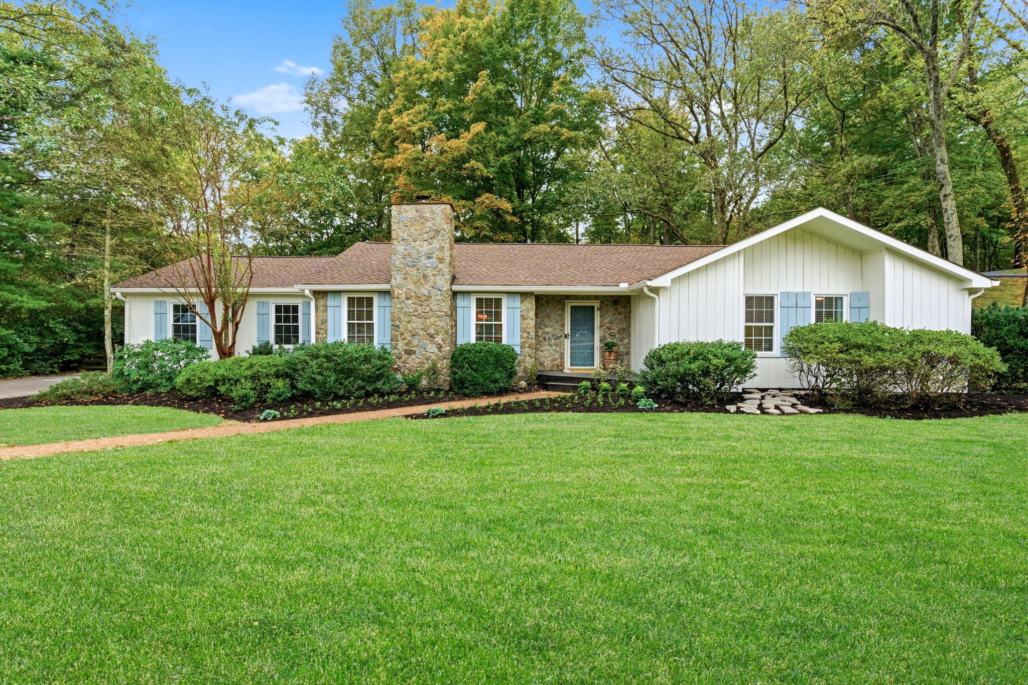 a front view of a house with a yard and trees