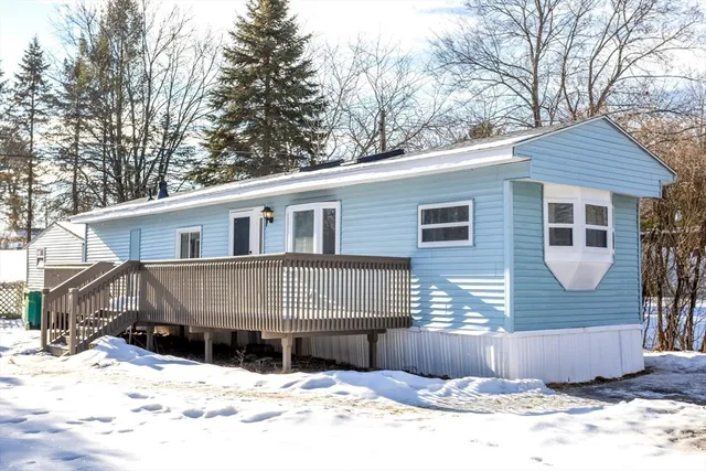 a front view of a house with a yard covered in snow