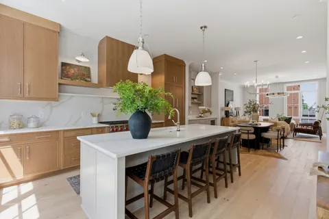 a kitchen with a table chairs sink and cabinets