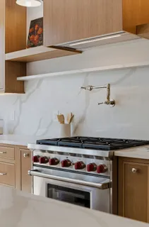 a stove top oven sitting inside of a kitchen