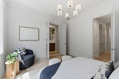 a bedroom with a bed chandelier and a couch