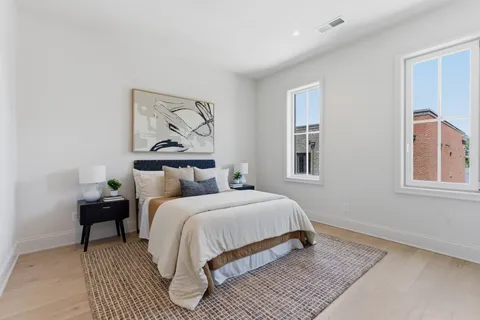 a bedroom with a bed and a painting on the wall