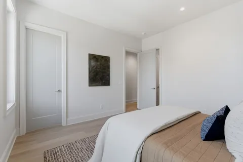 a bedroom with a bed and a painting on the wall