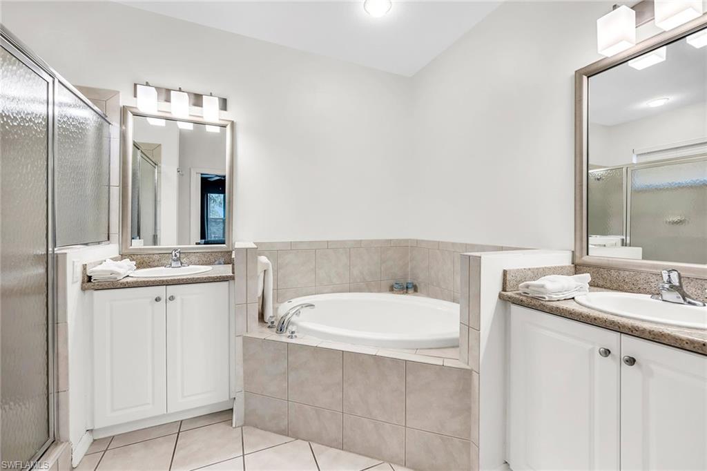 7930 Mahogany Run Lane, Unit 826 Naples, FL 34113 - Photo 18 of 50 a bathroom with a double vanity sink and mirror