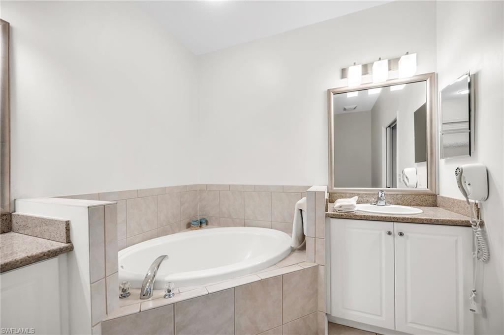 7930 Mahogany Run Lane, Unit 826 Naples, FL 34113 - Photo 50 of 50 a bathroom with a sink and a mirror