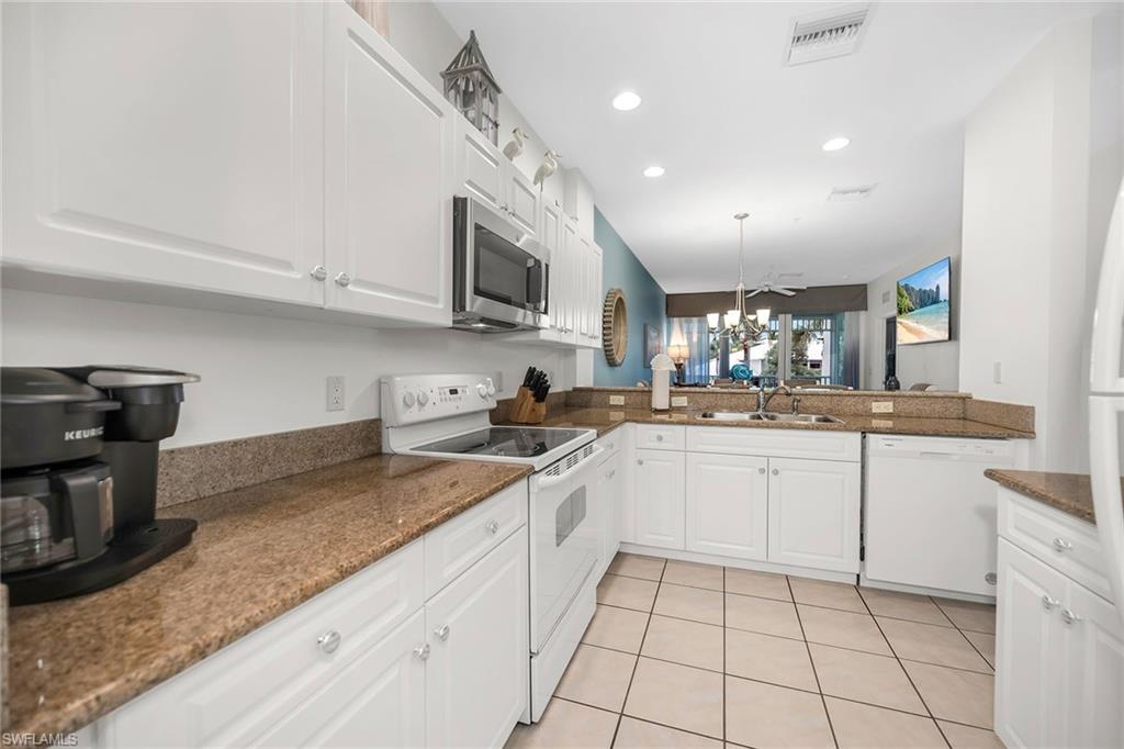 7930 Mahogany Run Lane, Unit 826 Naples, FL 34113 - Photo 8 of 50 a kitchen with stainless steel appliances granite countertop a sink and a stove