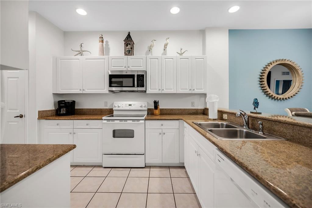 7930 Mahogany Run Lane, Unit 826 Naples, FL 34113 - Photo 9 of 50 a kitchen with granite countertop a sink stainless steel appliances and cabinets