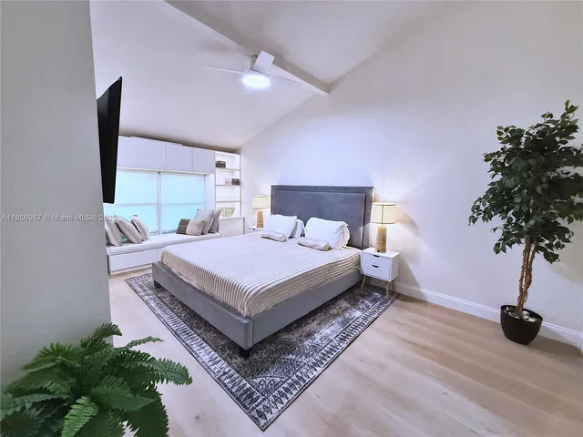 a bedroom with a bed lamp and a potted plant