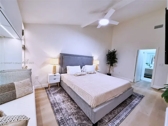 a bedroom with a large bed and a chandelier