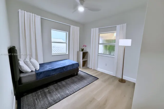 a spacious bedroom with a bed and wooden floor