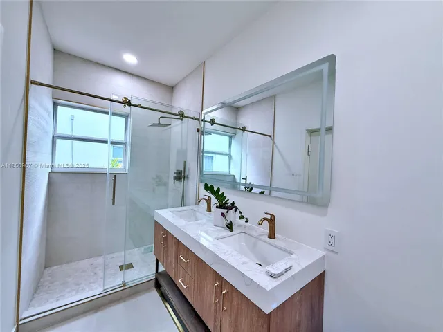 a bathroom with a shower sink and mirror