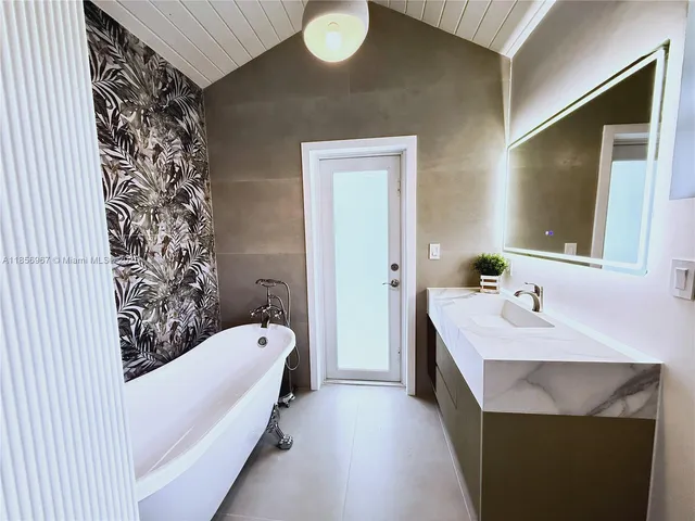 a bathroom with a tub sink and mirror