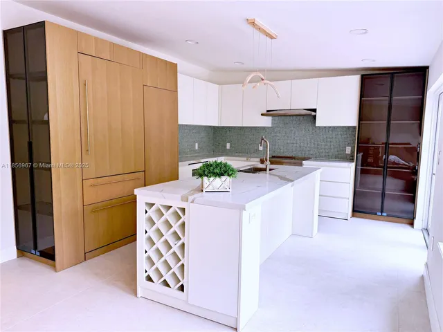 a kitchen with stainless steel appliances kitchen island granite countertop a refrigerator and a stove top oven