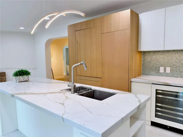 a kitchen with stainless steel appliances a sink a refrigerator and cabinets